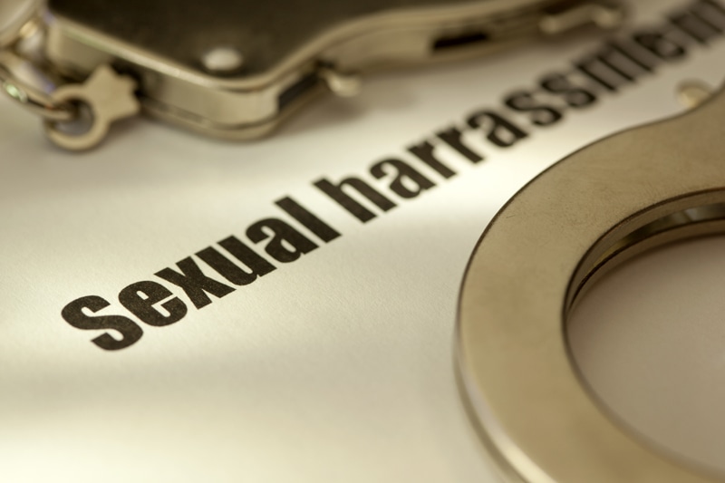 studio shot of word sexual harrassment with handcuff
